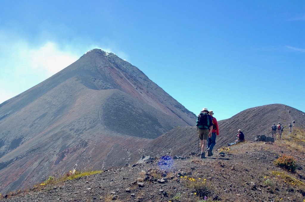 Hikers ascending the volcanic slopes of Acatenango with dramatic mountain views